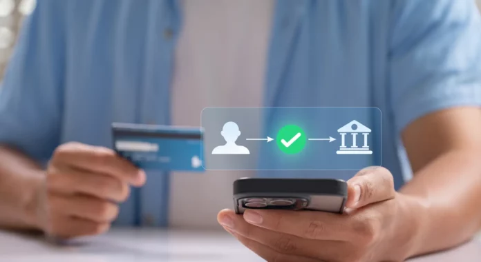 Persoană care ține un card și un telefon, într-o imagine despre transferuri bancare și bani primiți în cont.